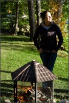 Woman standing next to a fire in a fire pit
