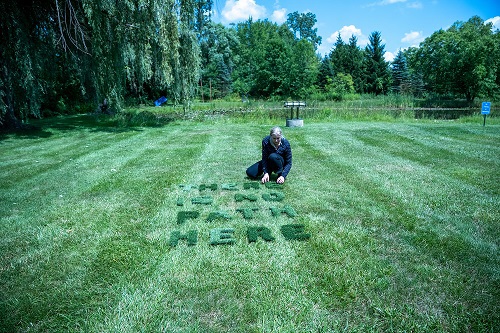Artist Kevin Brophy creating art outside on the grass